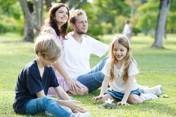Fototapeta premium Caucasian family parent and their children picnic at the park in morning.