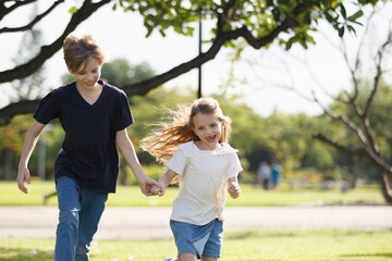 Fototapeta premium White children running together at the park.