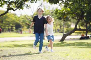 Fototapeta premium White children running together at the park.