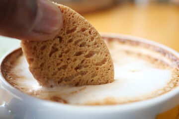  pouring sweet cookies in a coffee mug on wooden table 