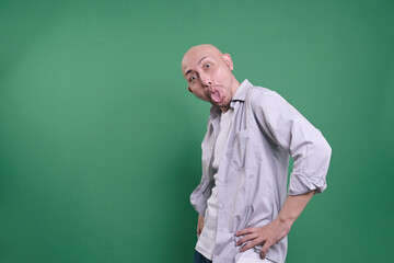 Funny Bald Man Mocking With Funny Face, Sticking Out His Tongue With Hand On Waist