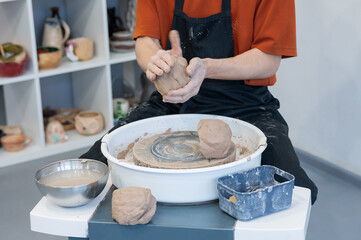 The potter kneads the clay before using it on the potter's wheel. Close-up of a man's hands. 