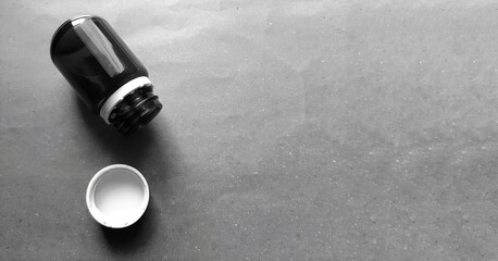 Twist top pill bottle, empty medicine bottle black and white photo with copy space