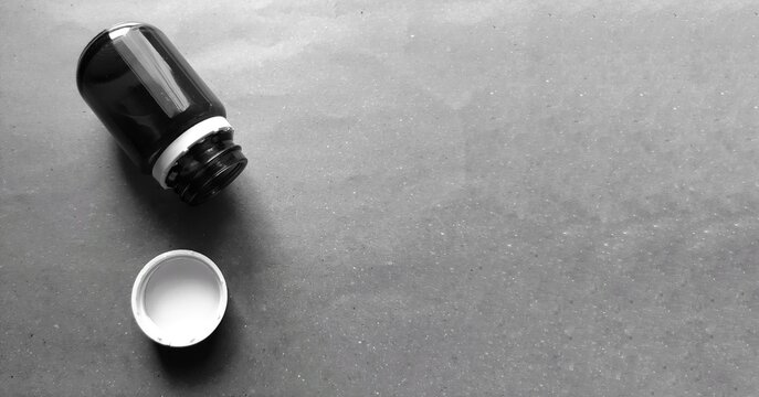 Twist top pill bottle, empty medicine bottle black and white photo with copy space