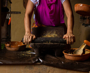 Latin woman traditional cook in the metate, hands cooking in a traditional way