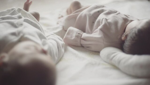 Close twins lying on futon with their hands on top of each other's (5)