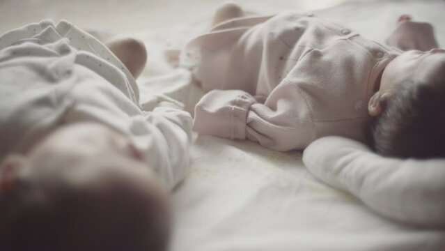 Close twins lying on futon with their hands on top of each other's (6)