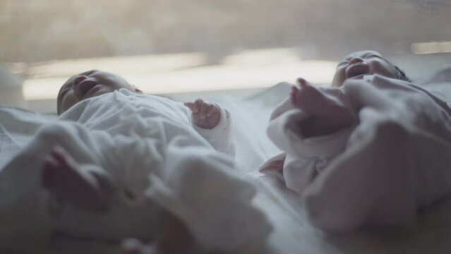 Close twins lying on futon with their hands on top of each other's (3)