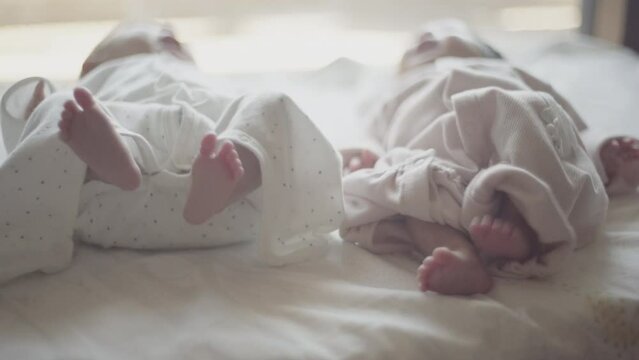 Close twins lying on the futon, legs flapping.