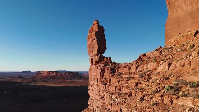 Aerial pass by balancing rock to reveal Utah desert at sunset
