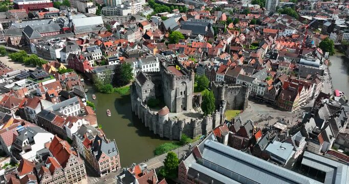 Gravensteen Castle, East Flanders, Ghent, Flemish Region, Belgium, June 2022. Drone medium height aerial orbit left above castle and Lieve Canal.