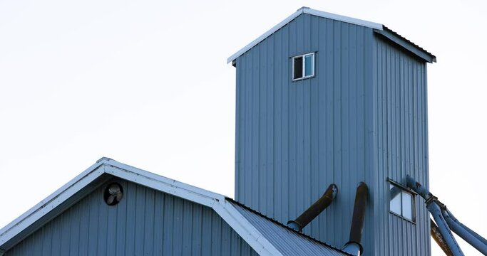 Rural Farm Building with Spinning Exhaust Fan in Evening Dusk, Static Shot, 4k60