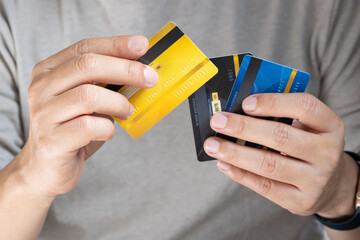 Man holding several credit cards and he is choosing a credit card to pay and spend Payment for...