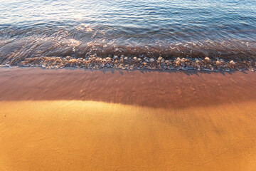 Soft wave of the sea on the sandy beach.