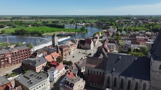 Flight along the town centre of Calbe Saale. On the right is St. Stefani Church. On the left is the town hall and town hall square. Behind it is a weir in the river Saale. Travel destination in Saxony