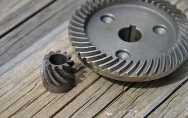 Obraz premium gears for angle grinder. two metal gears on a wooden background close-up. selective focus.