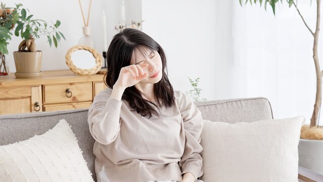 眠い目を擦る女性