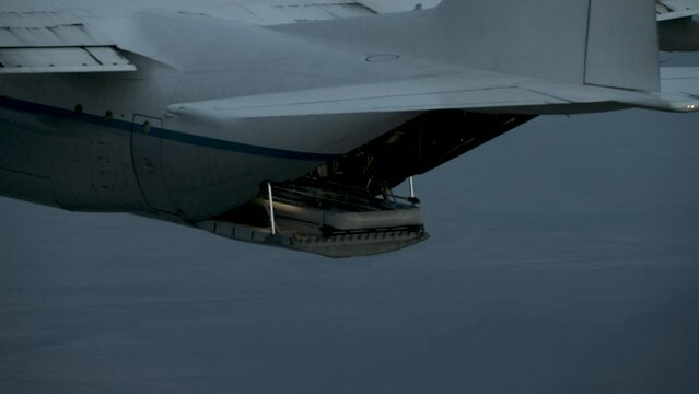 Parachuter sliding out the back of airborne airplane 