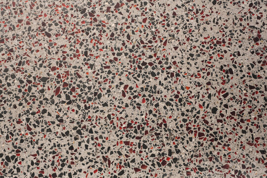 Sol en terrazzo gris avec &eacute;clats rouges