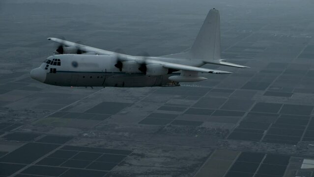 Cinematic zoom in on skydiver sliding out of c-130 plane at dusk