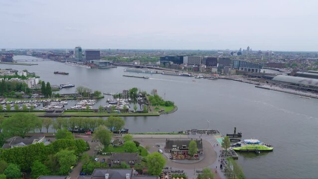 Aerial view of north and south Amsterdam and the IJ river with boats, tanker ships, on a cloudy spring day 