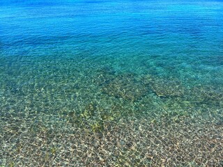 Blue sea clear calm water on pebble beach 