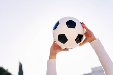 close up of hands holding a soccer ball, concept of football and sport, copy space for text