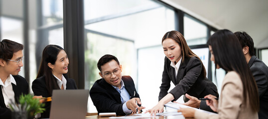 Diverse business workgroup team with asian woman leader discuss paperwork financial report statistical data, briefing project at office.