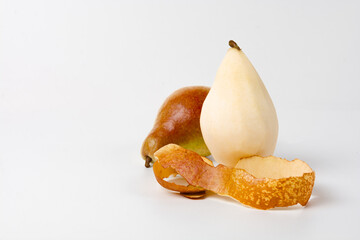 A close-up image of two pears, one with a brown skin and one with a yellow skin, lying on a white...