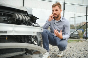 Man calling help after a car crash accident on the road