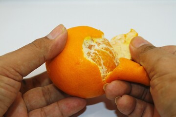 peeling oranges by hand, oranges with peeled skin
