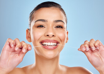 Dental floss, hands of woman and portrait in studio for healthy gums, teeth whitening or morning routine on blue background. Wellness, oral care and model for fresh breath, plaque or mouth hygiene