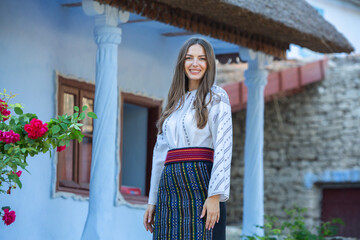 young girl wearing Romanian traditional blouse in the country. Authentic national costume of the Romanian tradition.