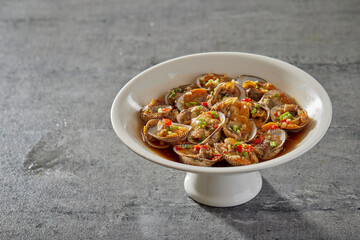 traditional chinese wok fried seafood fresh clam Lala with spicy chilli sauce in plate on grey stone table asian cafe hotel luxury halal food restaurant banquet menu