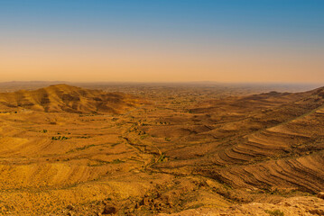 Magnificent mountainous landscape of the Medenine region of Tunisia. Stunning sunrise over a dry, arid, ochre-coloured mountain range.