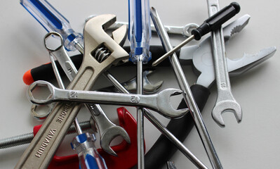 Different Hand Tools With Colored Handles In A Stack On White Surface Closeup Stock Photo
