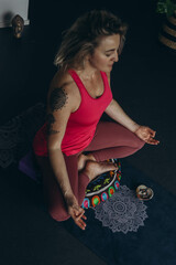 woman practices yoga and meditates in the lotus position at home