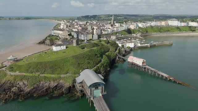 An aerial view of the of the Welsh harbour town of Tenby in Pembrokeshire, South Wales, on a sunny summer morning. Flying left to right around the boat launches and Tenby Castle.