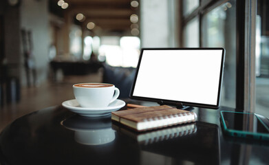 Comfortable workplace on table by the window in modern cafe with tablet, coffee drink and mobile phone, note book