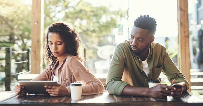 Unhappy, couple and ignore with technology in restaurant, conflict and argument with disagreement. Dating people, woman and angry man with mobile, affair and cheating girl on tablet in relationship