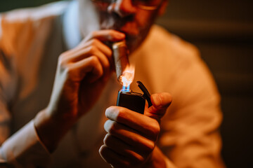 Valmiera, Latvia - September 9, 2023 -  Close-up of a person lighting a cigar with a lighter, showcasing a detailed and intimate moment of cigar smoking.