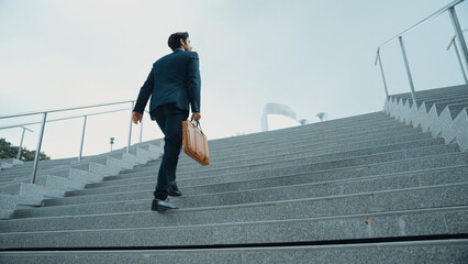 Top view of smart business man walking up stairs with bag in the hand. Professional project manager...