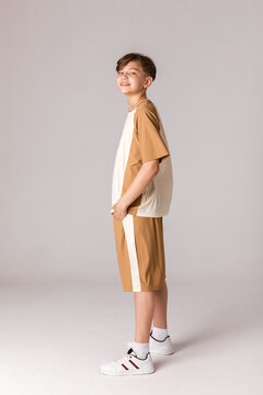 Full length side view shot of a teenage boy in sport clothes isolated on a white background. Sport fashion. Casual lifestyle. Copy space