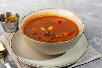 Tom yum soup with seafood, capers added nearby.