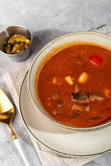 Tom yum soup with seafood, capers added nearby.