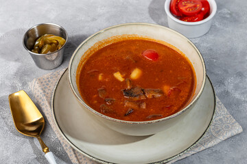 Tom yum soup with seafood, capers added nearby.