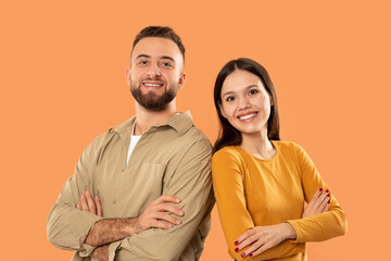 A man and a woman are standing next to each other, facing forward. They are wearing casual clothing and appear to be engaged in conversation