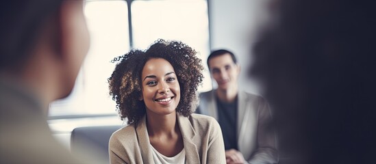 African woman at group therapy session shares personal story with colleagues as a business coach leads with copy space image