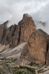 Rifugio Antermoia hut with Testone del Rifugio and higher Croda del Lago mountain peaks above from Mantel hill in the Dolomites