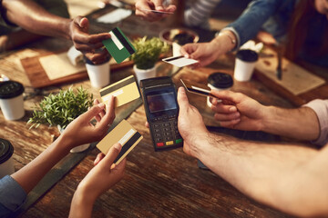 Hands, credit card or friends at coffee shop for payment, online transaction or pos machine in top view. Waiter, people or debit at cafe service with group together for finance, banking or share bill